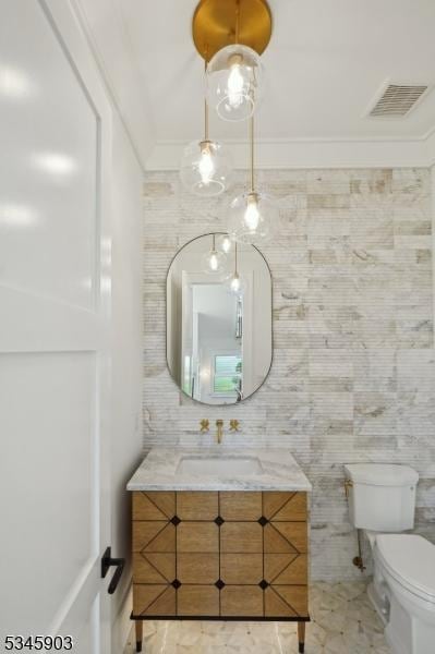 bathroom with toilet, visible vents, marble finish floor, and vanity