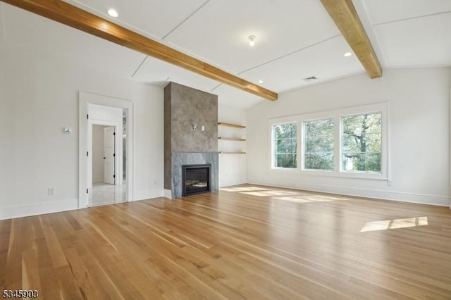 unfurnished living room featuring a fireplace, wood finished floors, baseboards, lofted ceiling with beams, and recessed lighting