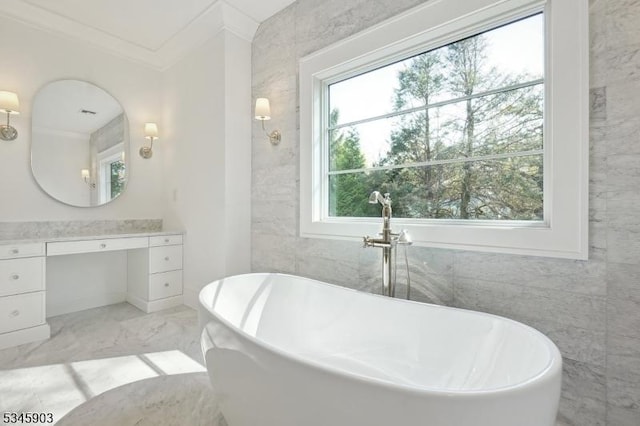 bathroom featuring a freestanding bath, vanity, tile walls, and marble finish floor