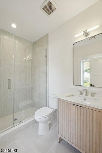 bathroom featuring vanity, toilet, tile patterned floors, visible vents, and a stall shower