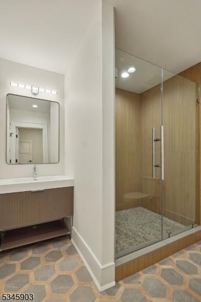 full bathroom with baseboards, recessed lighting, a stall shower, and vanity