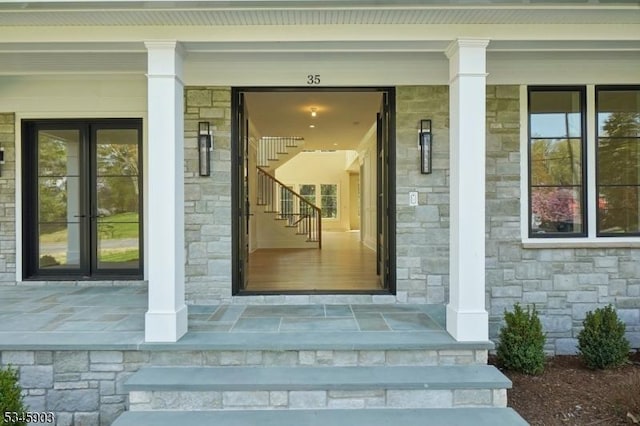 property entrance featuring covered porch and stone siding