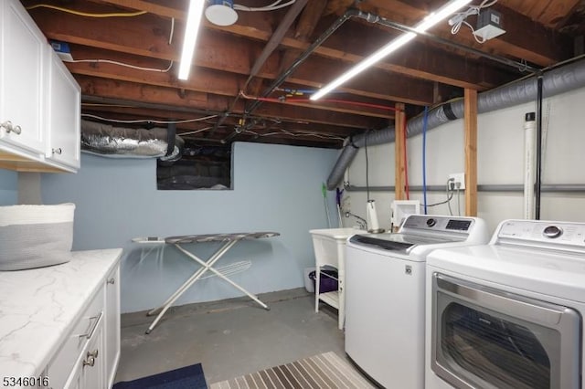 laundry room with washing machine and clothes dryer and cabinet space