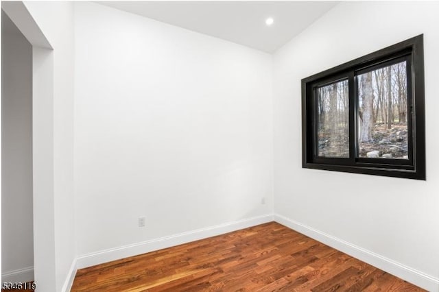 unfurnished room featuring wood finished floors, baseboards, and recessed lighting