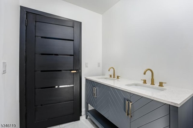 bathroom with marble finish floor, a sink, and double vanity