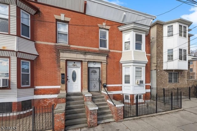 multi unit property featuring brick siding, fence, and entry steps