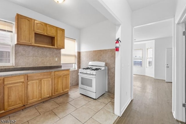 kitchen with wainscoting and white gas stove