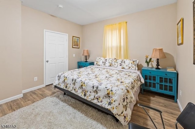 bedroom with baseboards and wood finished floors