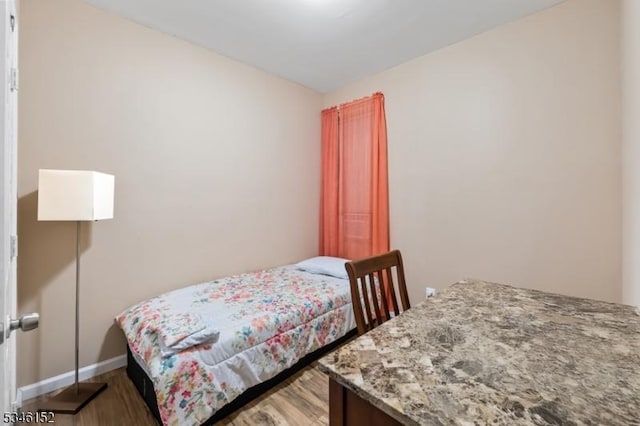 bedroom featuring baseboards and wood finished floors