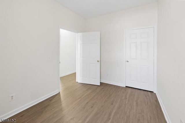 unfurnished bedroom with baseboards and wood finished floors