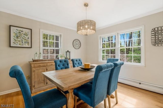 dining area featuring baseboard heating, baseboards, light wood finished floors, a chandelier, and ornamental molding