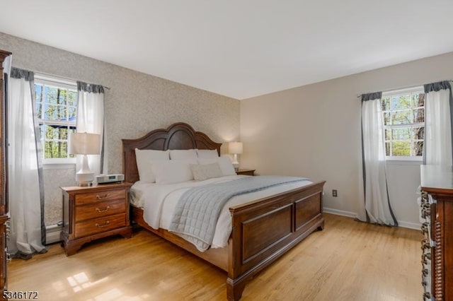 bedroom with baseboards and light wood finished floors