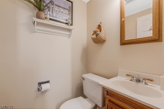half bath featuring vanity, visible vents, and toilet