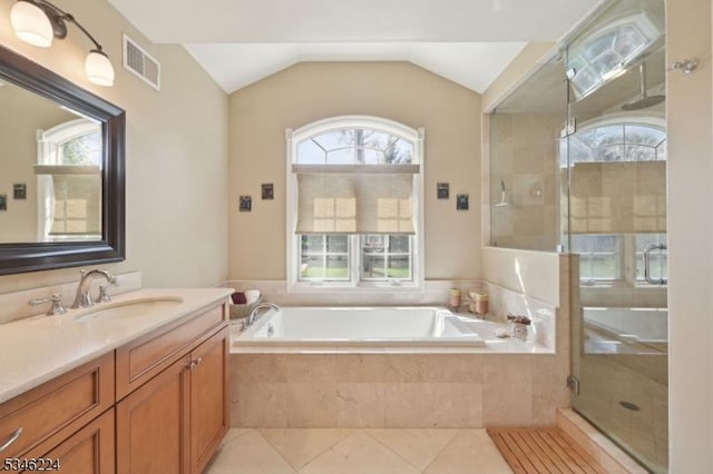 bathroom featuring visible vents, plenty of natural light, a garden tub, and vanity