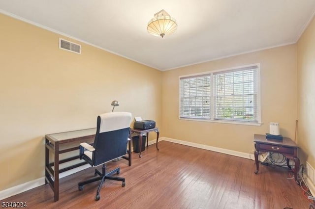 office area with crown molding, baseboards, wood finished floors, and visible vents