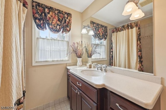 full bath featuring vanity, baseboards, and visible vents