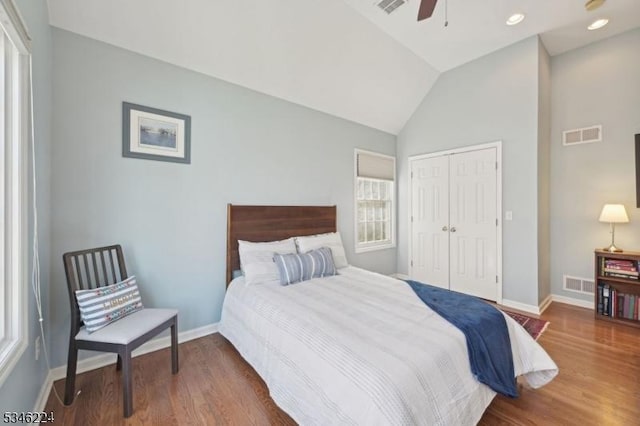 bedroom featuring baseboards, wood finished floors, and lofted ceiling