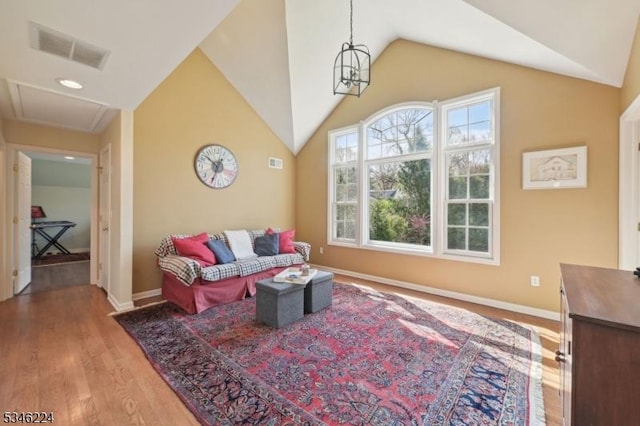 living area with visible vents, baseboards, wood finished floors, and vaulted ceiling