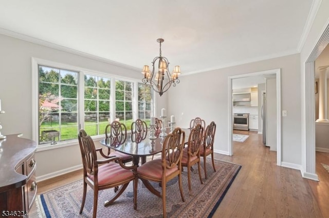 dining space with an inviting chandelier, ornamental molding, wood finished floors, and a healthy amount of sunlight