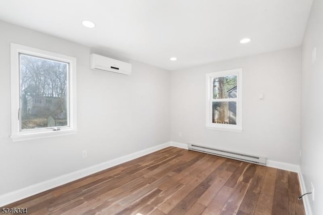 spare room featuring recessed lighting, baseboard heating, baseboards, a wall mounted air conditioner, and wood finished floors