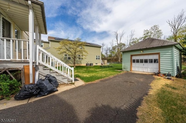 649 N Avenue Ext, Dunellen Boro, NJ 08812 - view of side of home with an outdoor structure, a detached garage, a lawn, and asphalt driveway