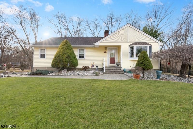 ranch-style home with a chimney and a front yard