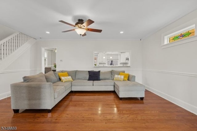 living area with stairway, a ceiling fan, wood finished floors, baseboards, and recessed lighting