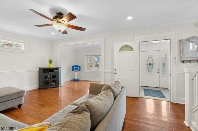 living area with a ceiling fan, wood finished floors, recessed lighting, and ornamental molding