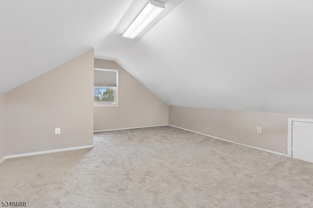 bonus room with carpet floors, lofted ceiling, and baseboards