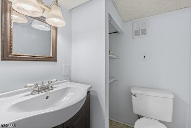 bathroom featuring visible vents, toilet, and vanity