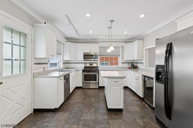 kitchen featuring beverage cooler, a sink, crown molding, appliances with stainless steel finishes, and white cabinetry
