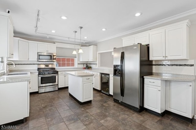 kitchen with white cabinets, wine cooler, a sink, tasteful backsplash, and appliances with stainless steel finishes