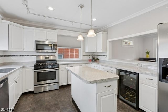 kitchen with a center island, crown molding, beverage cooler, light countertops, and appliances with stainless steel finishes