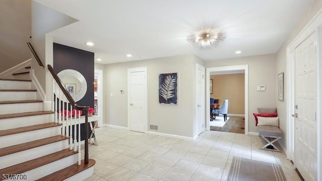entryway with stairway, light tile patterned floors, baseboards, and recessed lighting