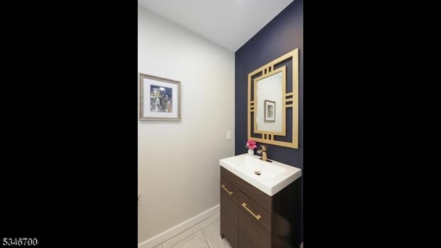 bathroom with baseboards, vaulted ceiling, and vanity
