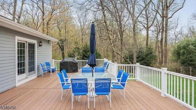wooden deck featuring outdoor dining space and grilling area