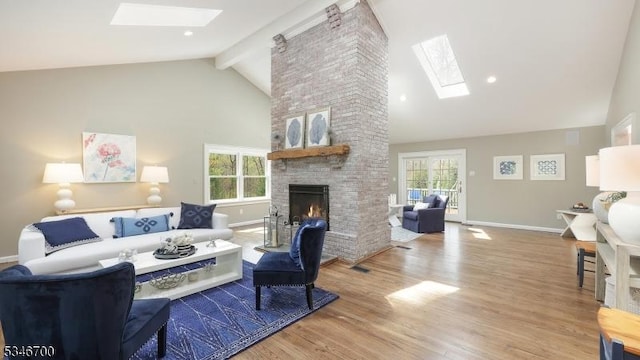 living room with a skylight, beam ceiling, high vaulted ceiling, and a fireplace