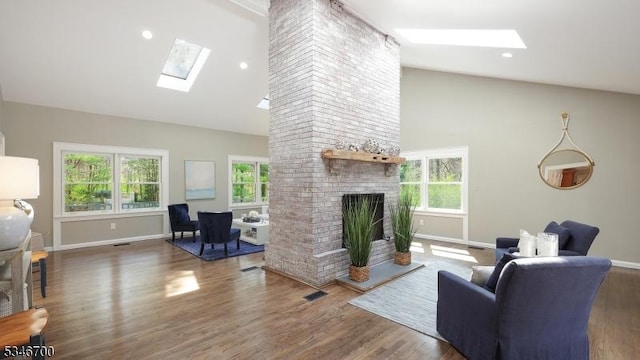 living room featuring a skylight, high vaulted ceiling, baseboards, and a wealth of natural light