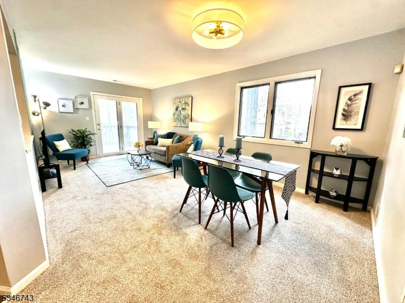 dining space featuring baseboards and light carpet
