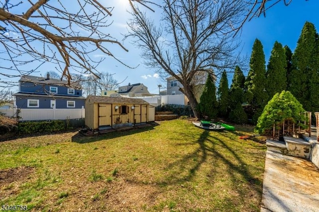 view of yard with a shed, an outbuilding, and fence