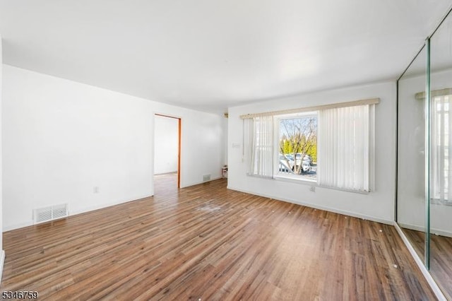 spare room with visible vents and wood finished floors