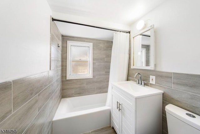 full bathroom with toilet, vanity, tile walls, and shower / bath combo with shower curtain