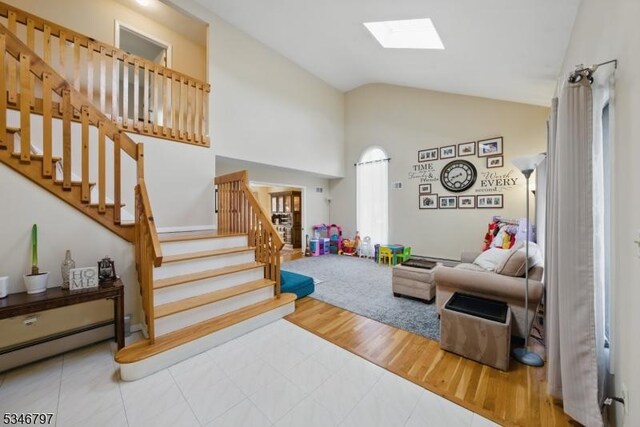100 Toner Rd, Boonton Town, NJ 07005 - living area with high vaulted ceiling, a skylight, a baseboard radiator, wood finished floors, and stairway