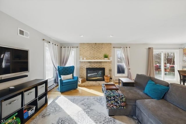 100 Toner Rd, Boonton Town, NJ 07005 - living room with visible vents, baseboard heating, a fireplace, and wood finished floors