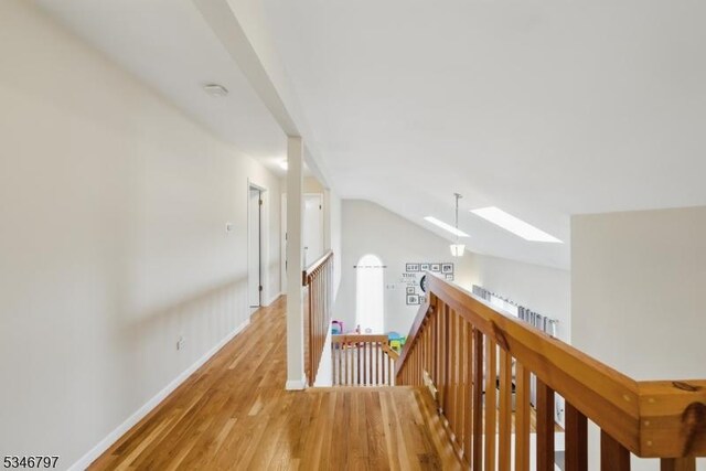 100 Toner Rd, Boonton Town, NJ 07005 - hall with baseboards, an upstairs landing, light wood-style floors, and lofted ceiling with skylight