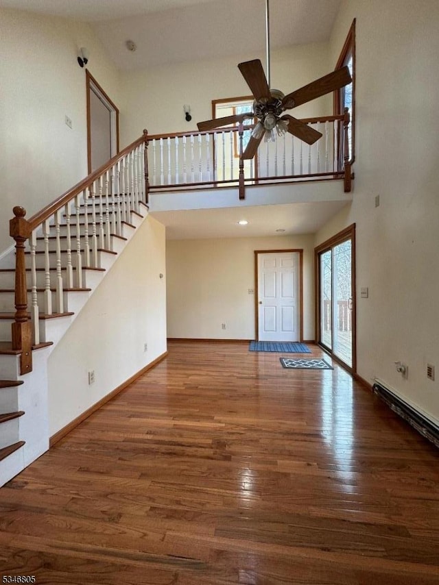 57 Park Rd, Sparta Twp, NJ 07871 - unfurnished living room with a high ceiling, a ceiling fan, wood finished floors, stairs, and baseboards