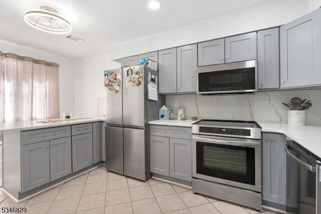 4 Village Way Unit 3, Vernon Twp, NJ 07462 - kitchen with gray cabinetry, a peninsula, and appliances with stainless steel finishes