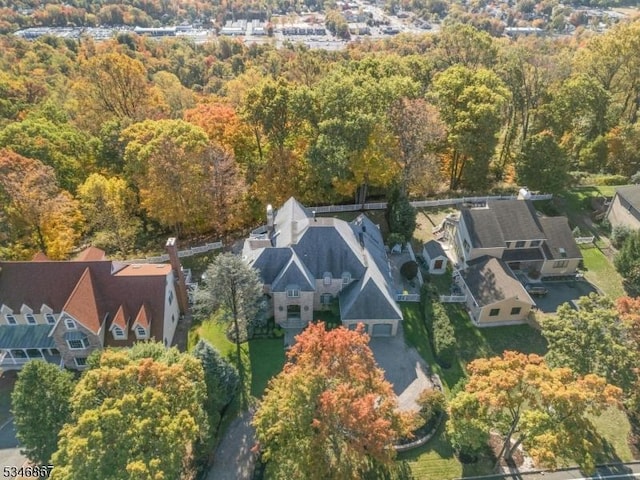 drone / aerial view featuring a residential view and a view of trees