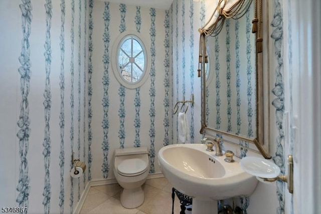 bathroom featuring tile patterned floors, toilet, and a sink