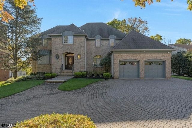 french country style house with a garage, brick siding, and curved driveway